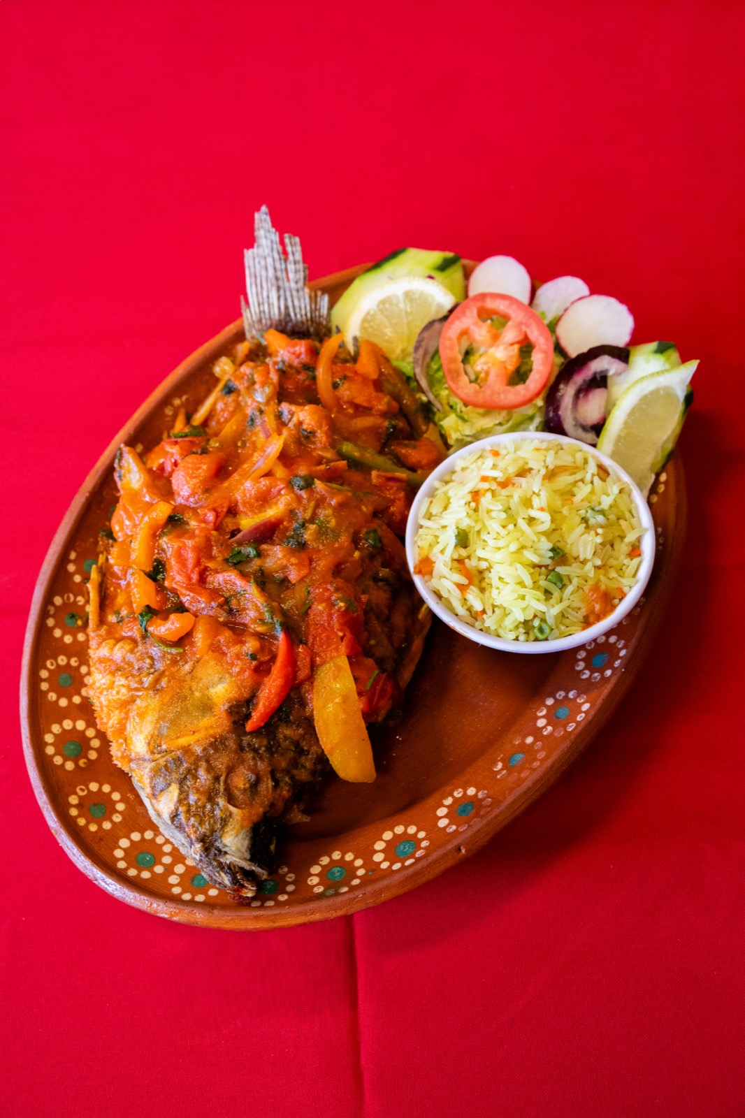Whole fried fish, smothered in tomato pepper sauce